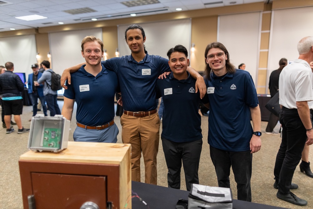 Four Mines students who won second place in the Senior Capstone Design project stand together in front of their engineering project.