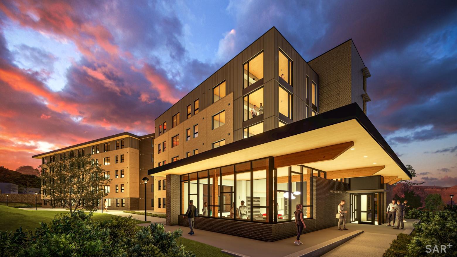 Building 2 of the Mines Park project at night with lights shining through glass windows.