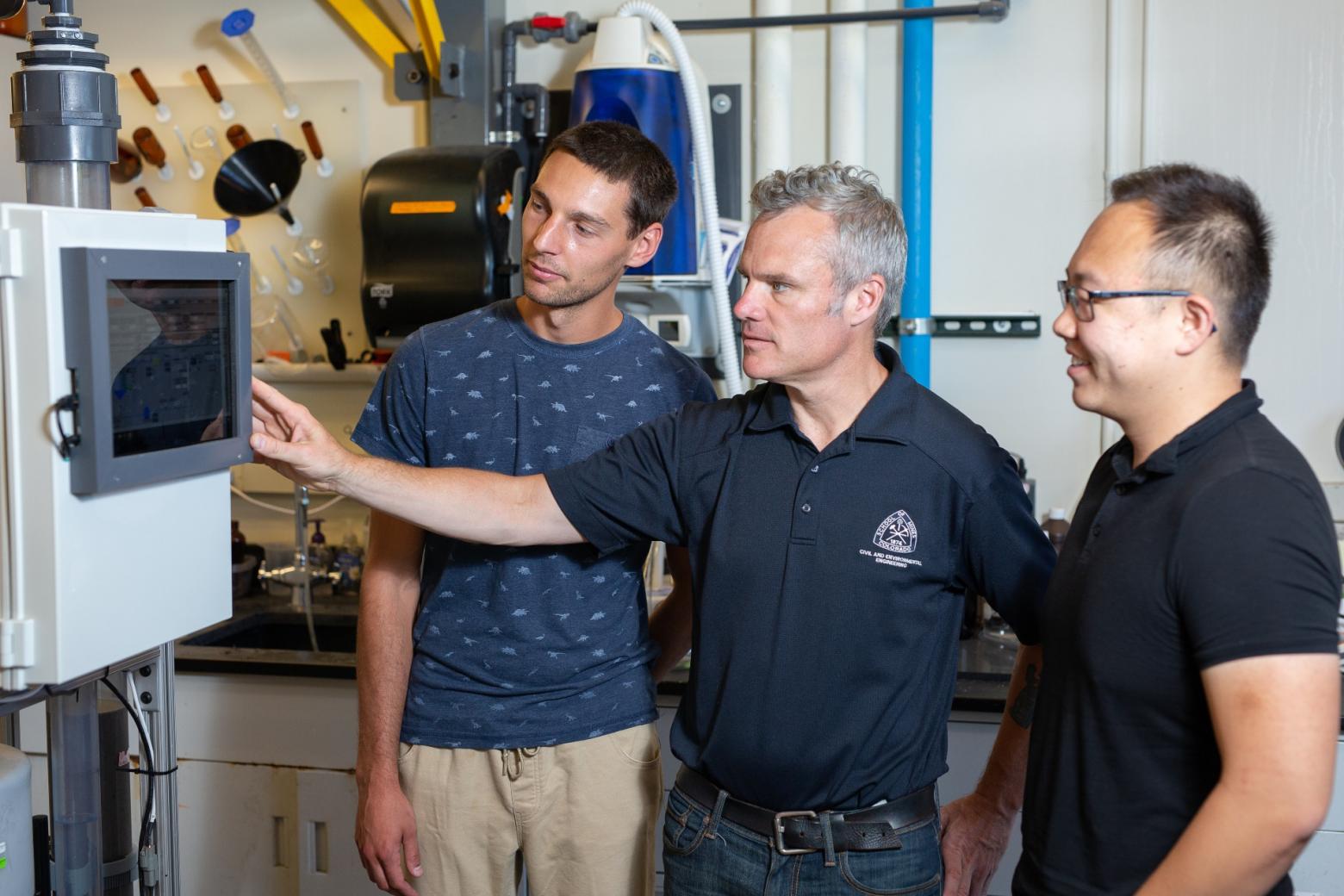 Mines team of students and faculty stand in front of engineering equipment designed to eliminate PFAS chemicals.