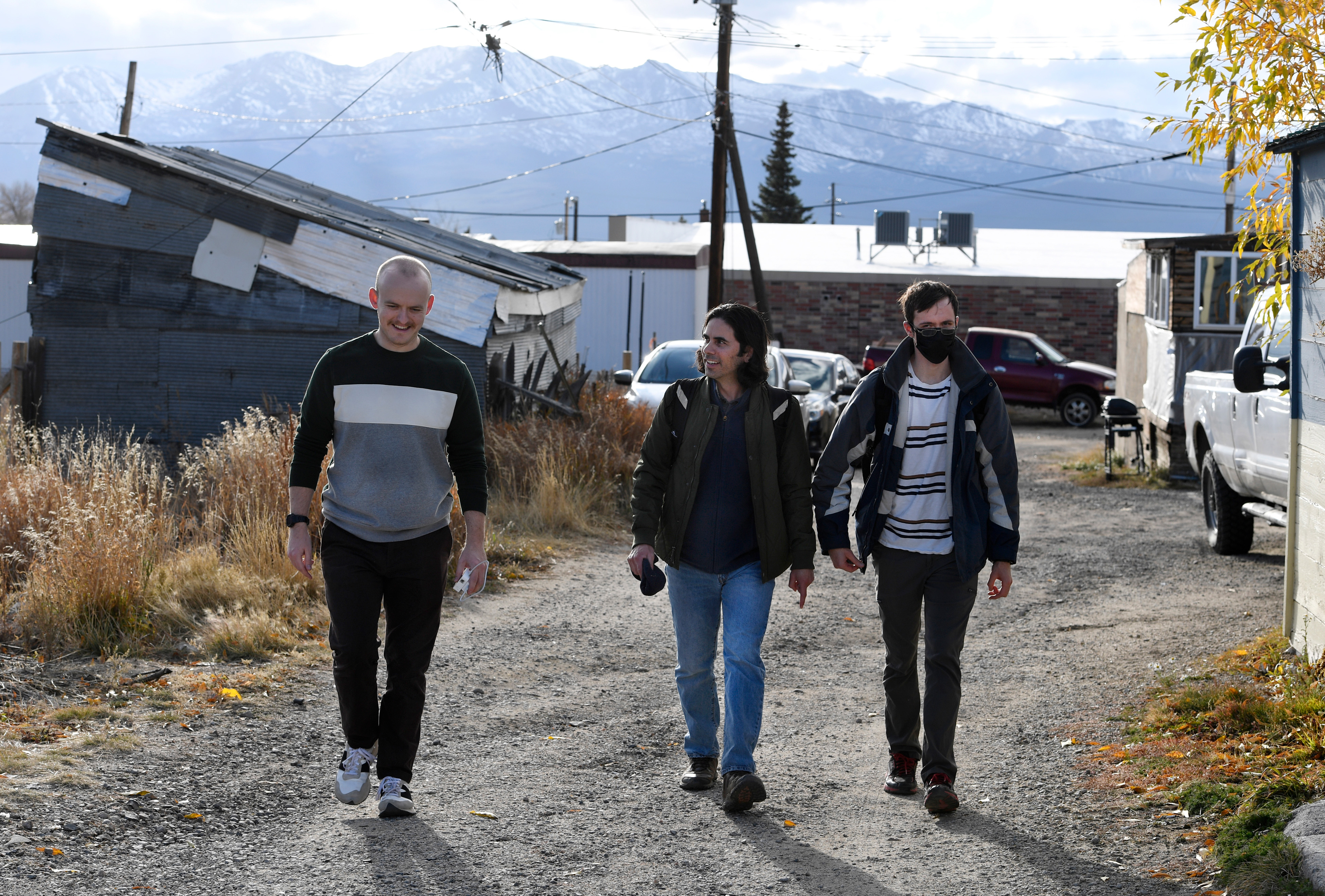 Mines professor Paulo Tabares-Velasco walks along a dirt road in a small Colorado town with community members.