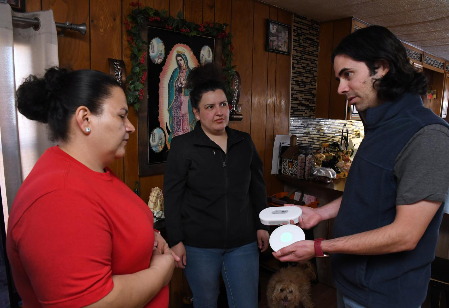 Mines assistant professor of mechanical engineering Paulo Tabares-Velasco stands in a kitchen with two community members showing them energy efficient tools for the home.
