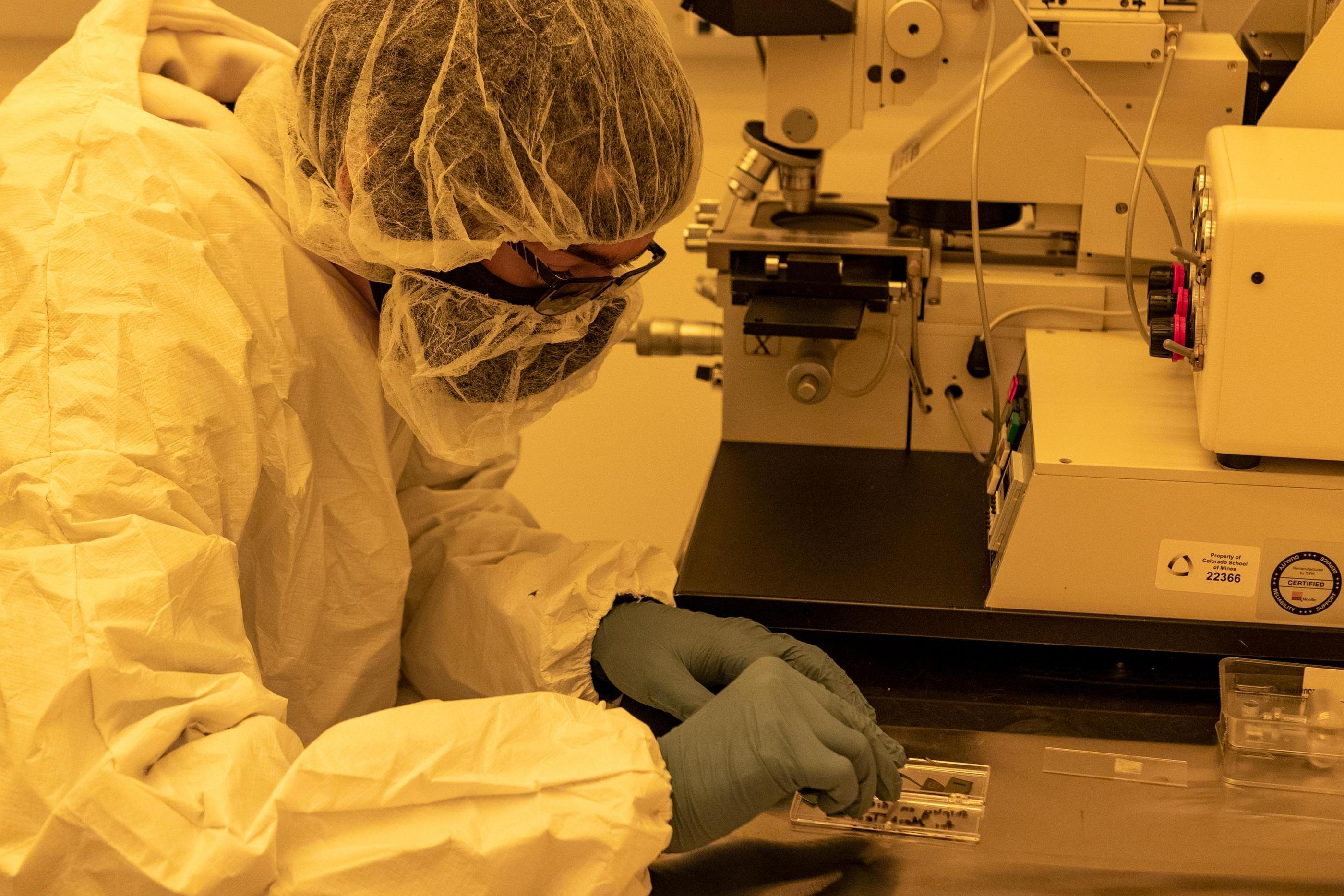 Researcher in a white protective suit works in a clean room