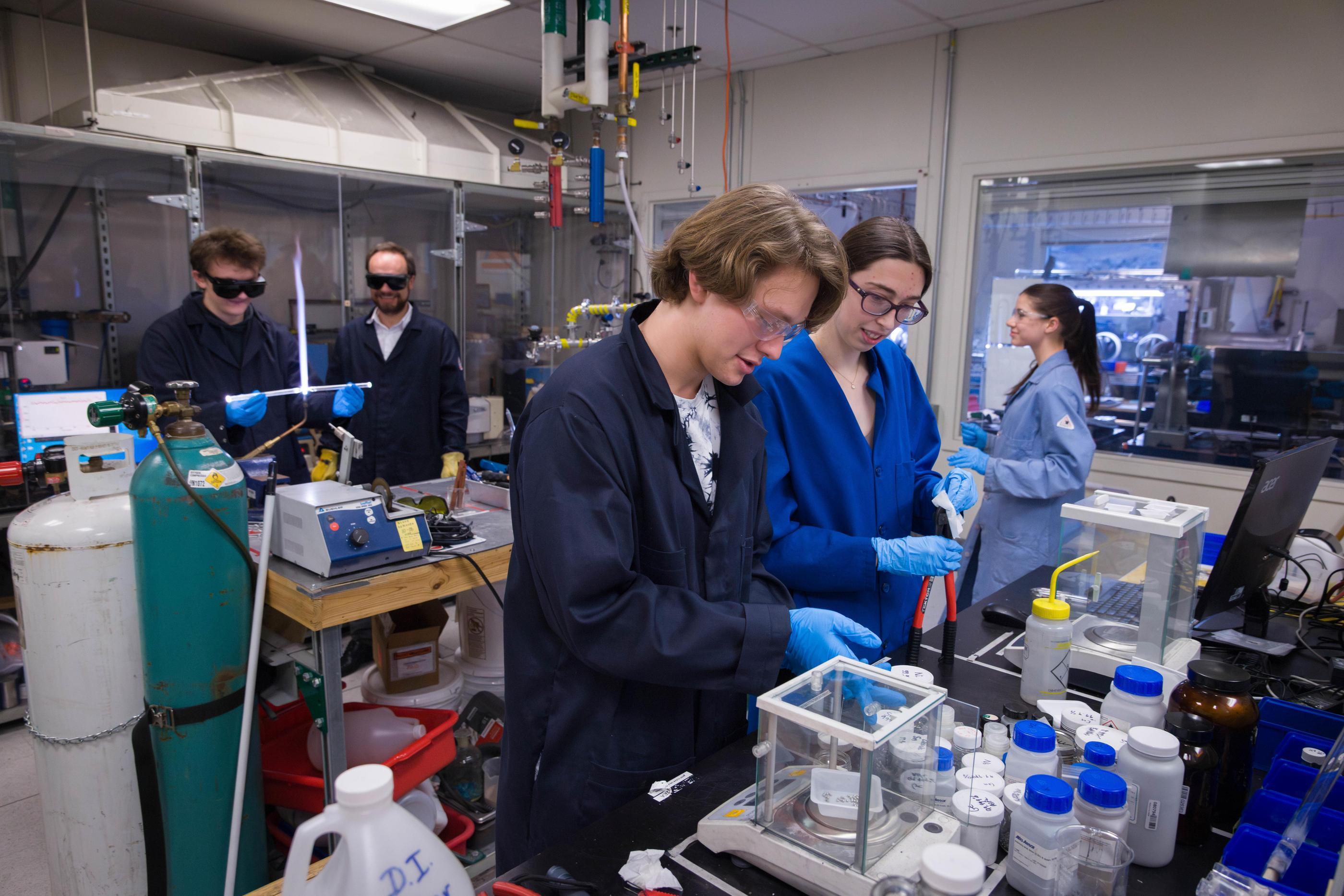 two students in lab coats work in a quantum materials lab