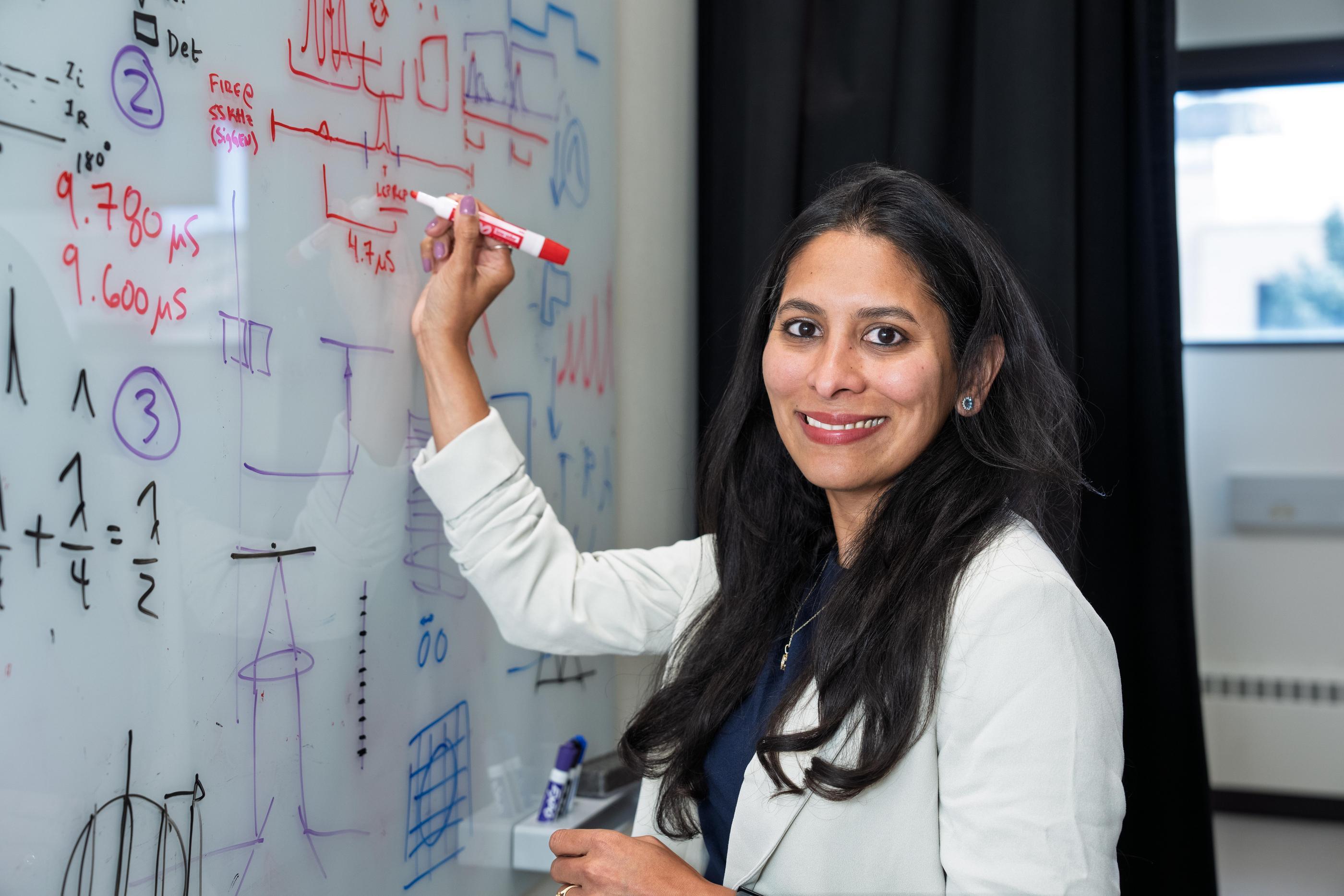 Yamuna Phal writes on a white board