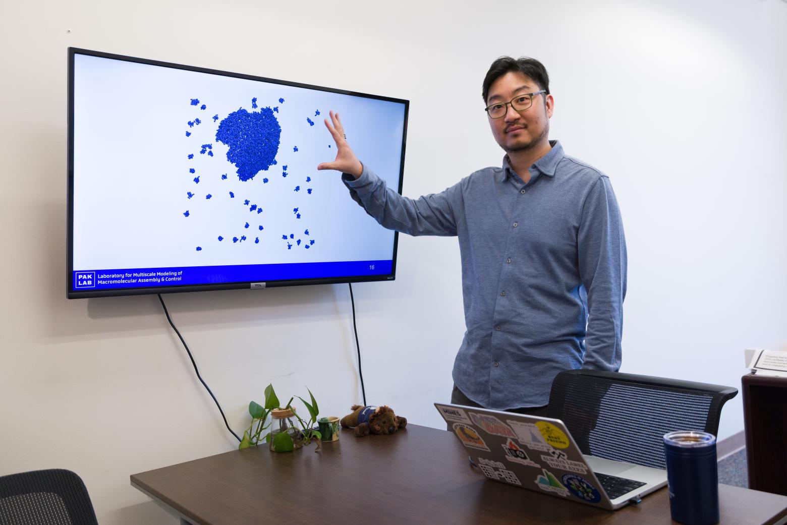 Alex Pak standing in front of a display board