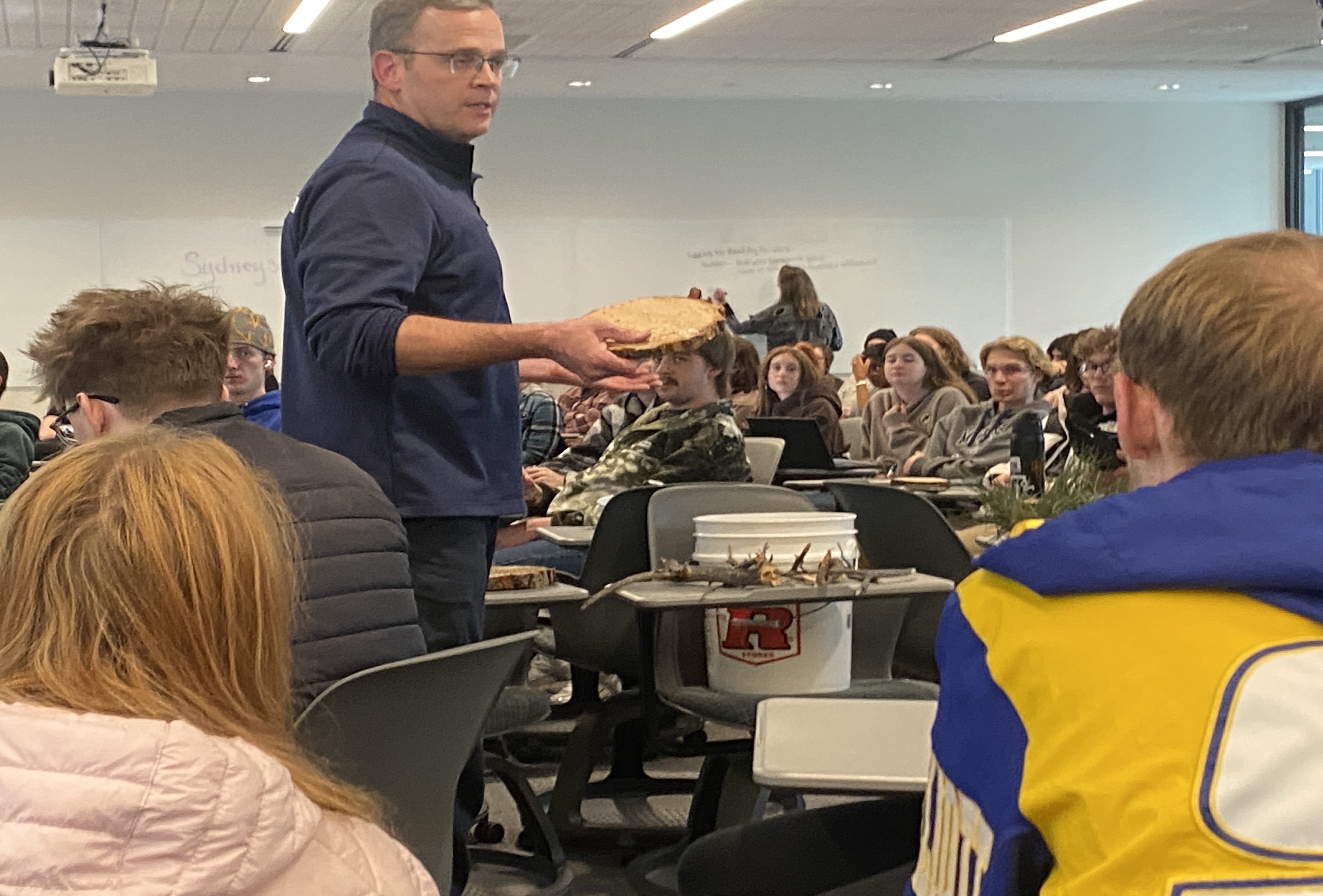 Jason Puffett, division chief of Evergreen Fire's Wildland Division, shows School of Mines students the types of forest waste materials for which they’re trying to find long-term solutions.