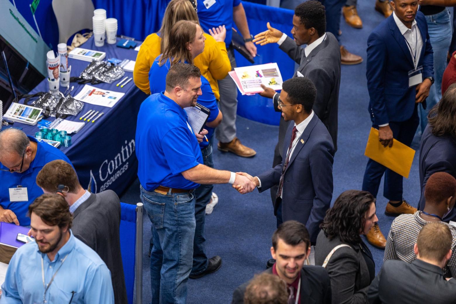 Mineral and Energy Economics master's student Abdallah El Badaoui shakes hands with a recruiter.