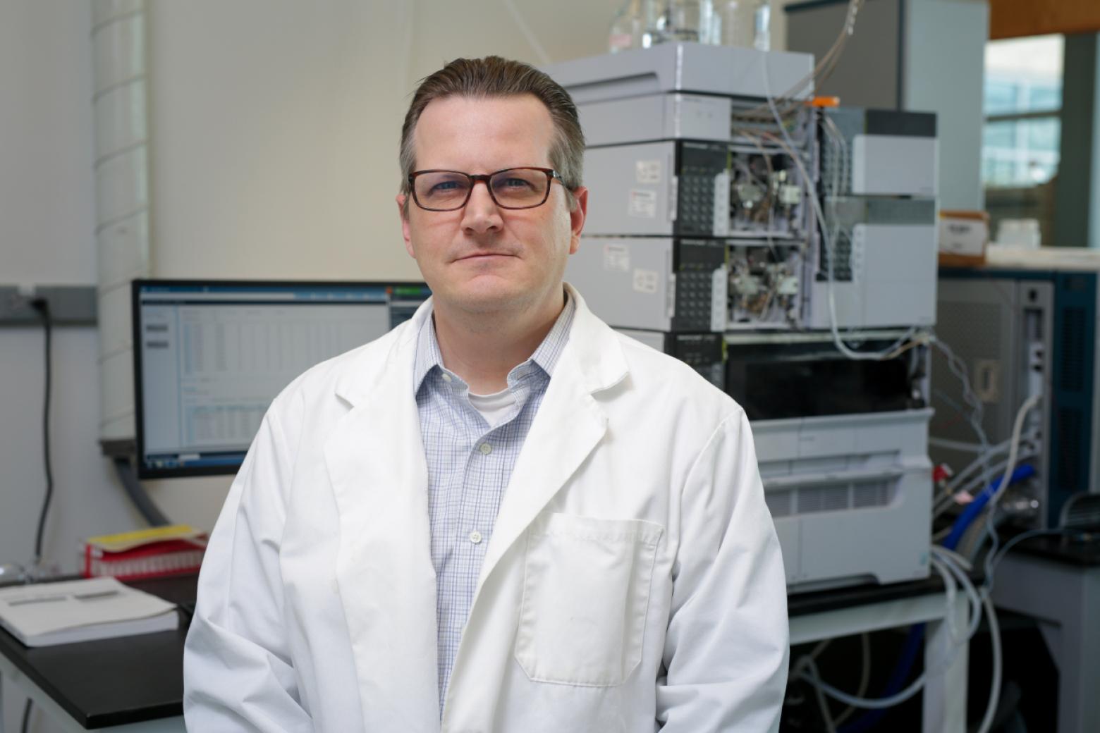 Christopher Higgins posing for a photo in his lab