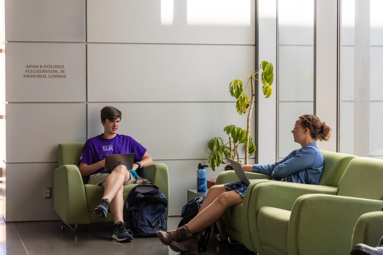 Mines students sit in green chairs in a study area on campus made for collaborating.