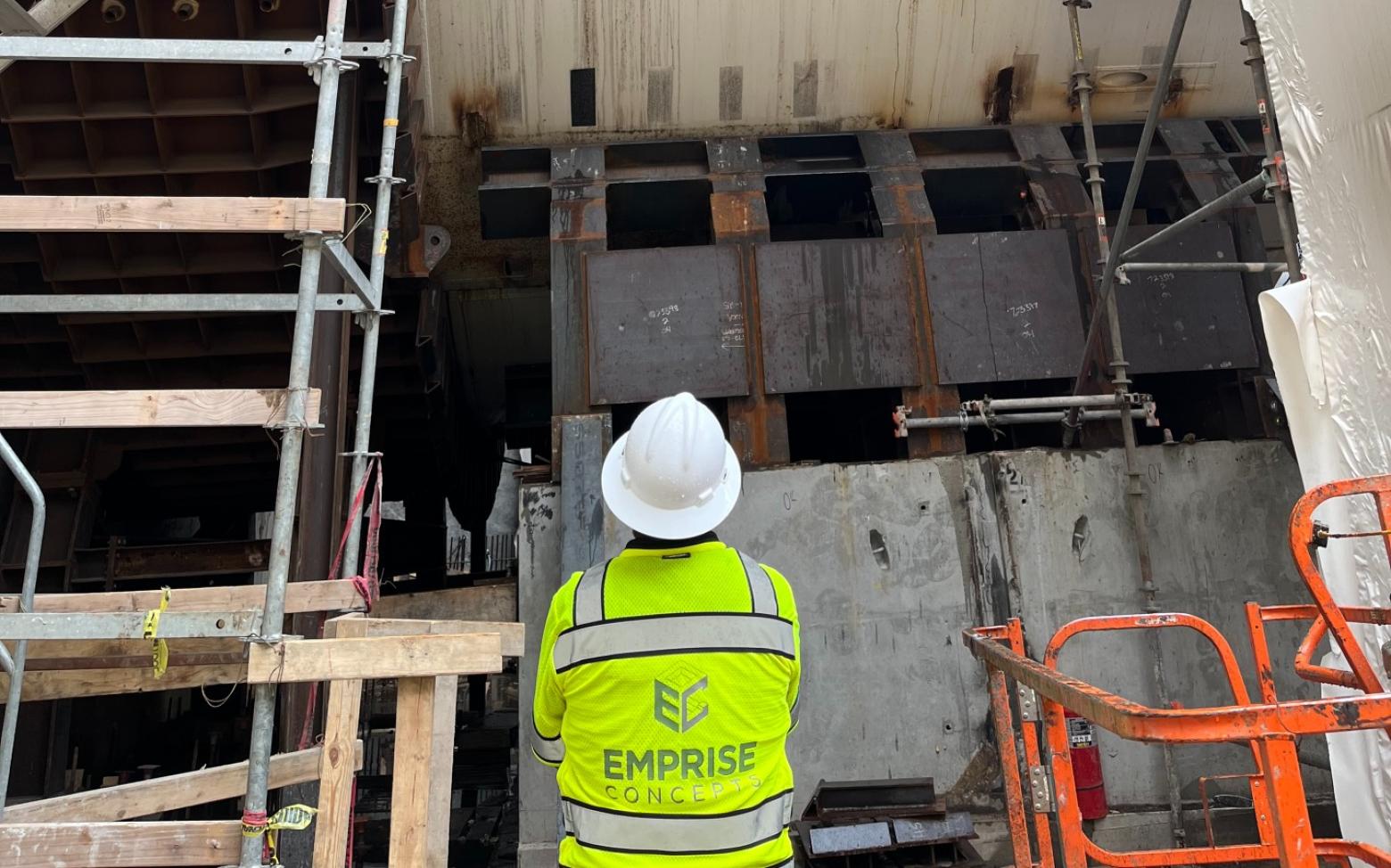 Mines alum Jacob Grasmick wears a hard hat and safety vest at a construction site where he is applying his graduate research.