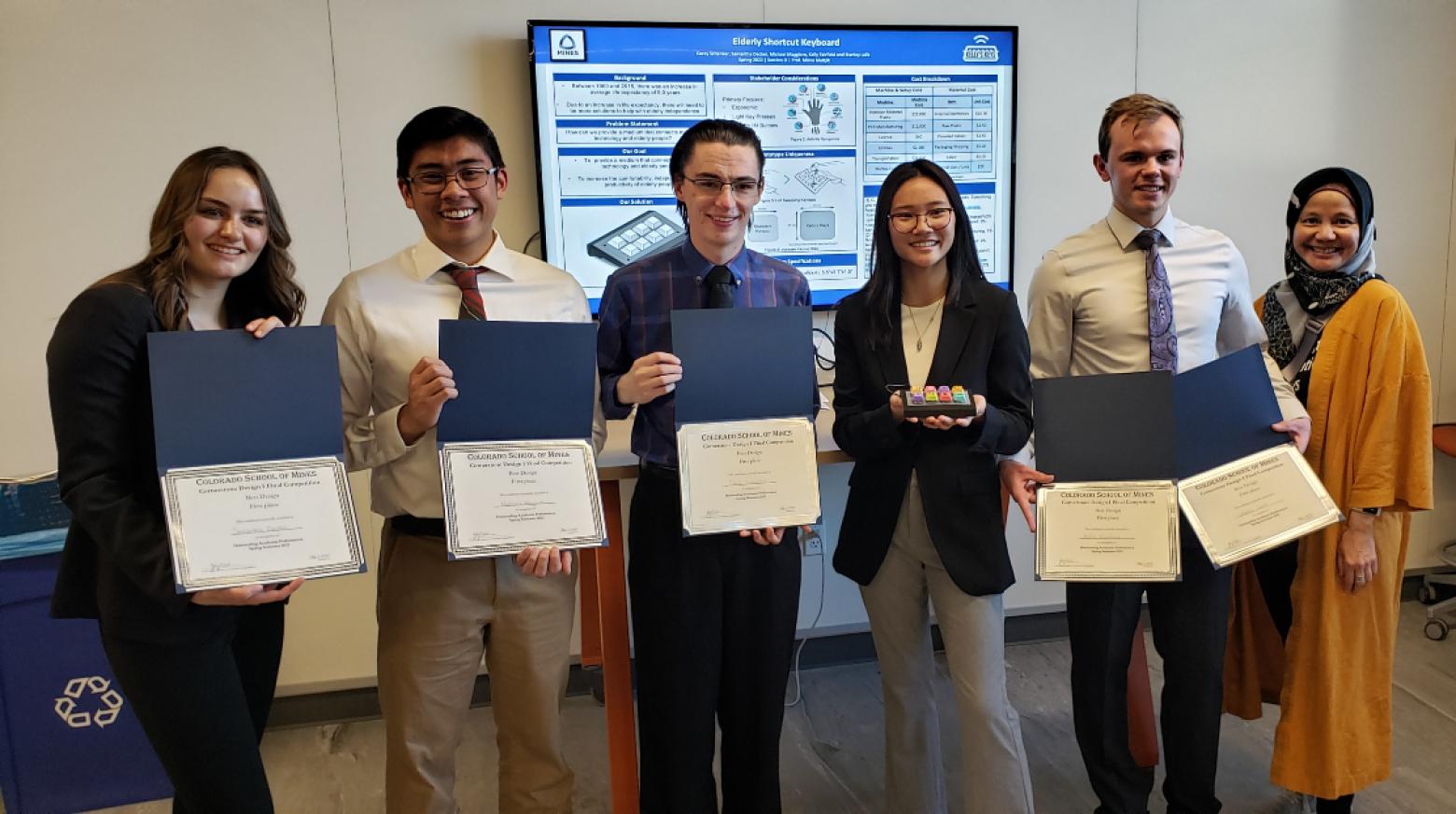 A group of students poses with certificates and their faculty advisor