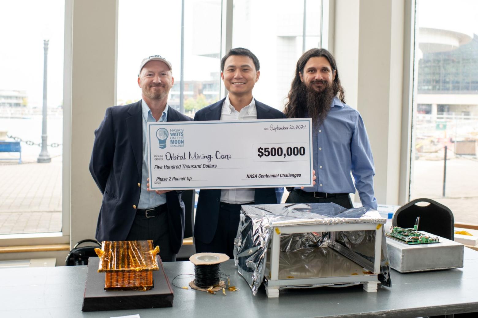 Two Mines students and mentor pose with a check for $500,000