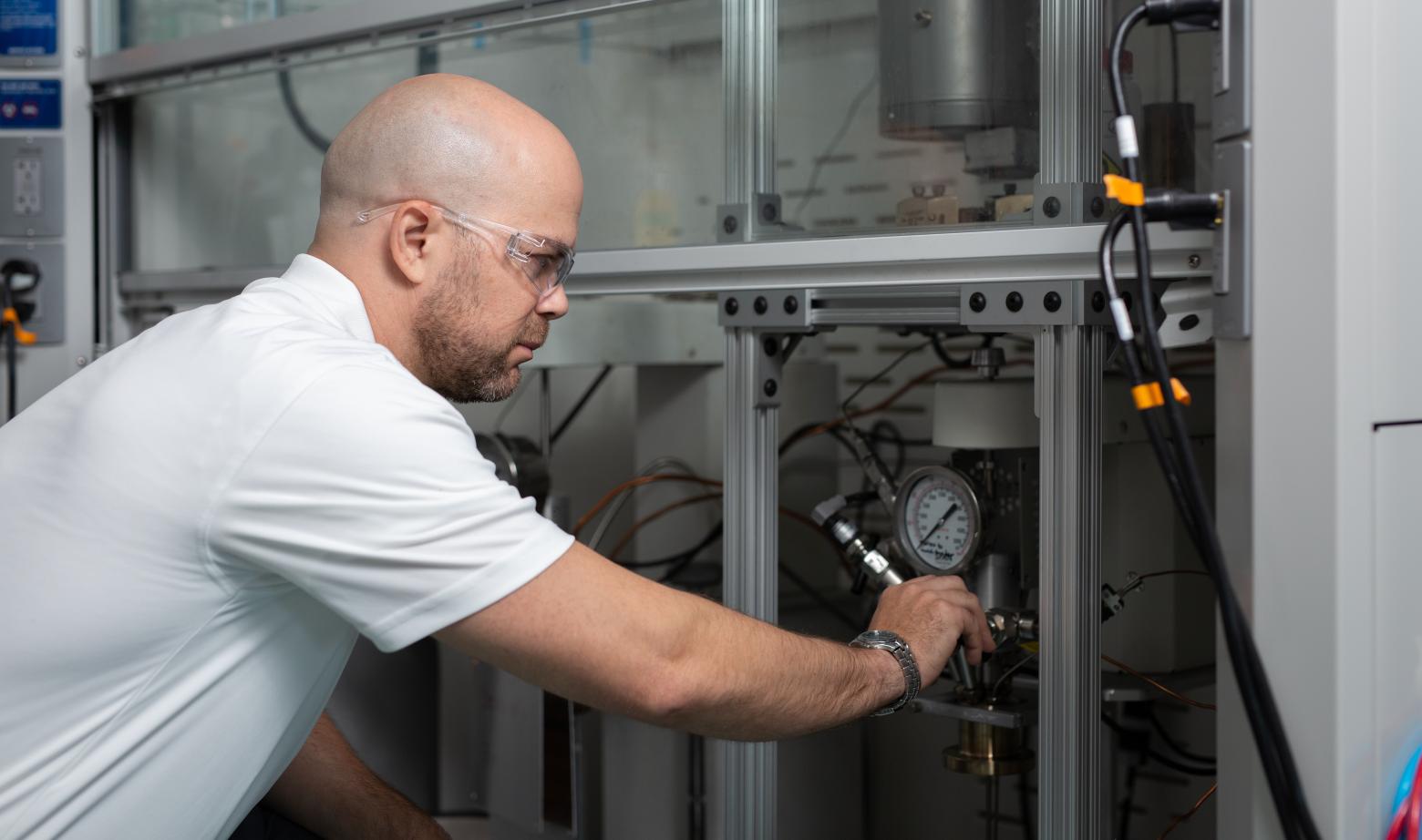 Timothy Strathmann makes adjustments to a reactor system