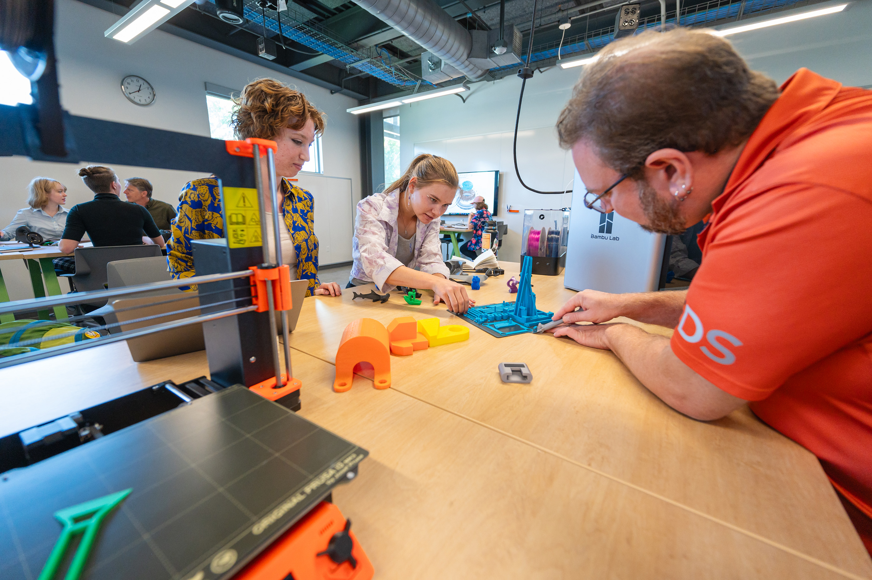 A Mines professor working with two students on 3D-printed prototypes