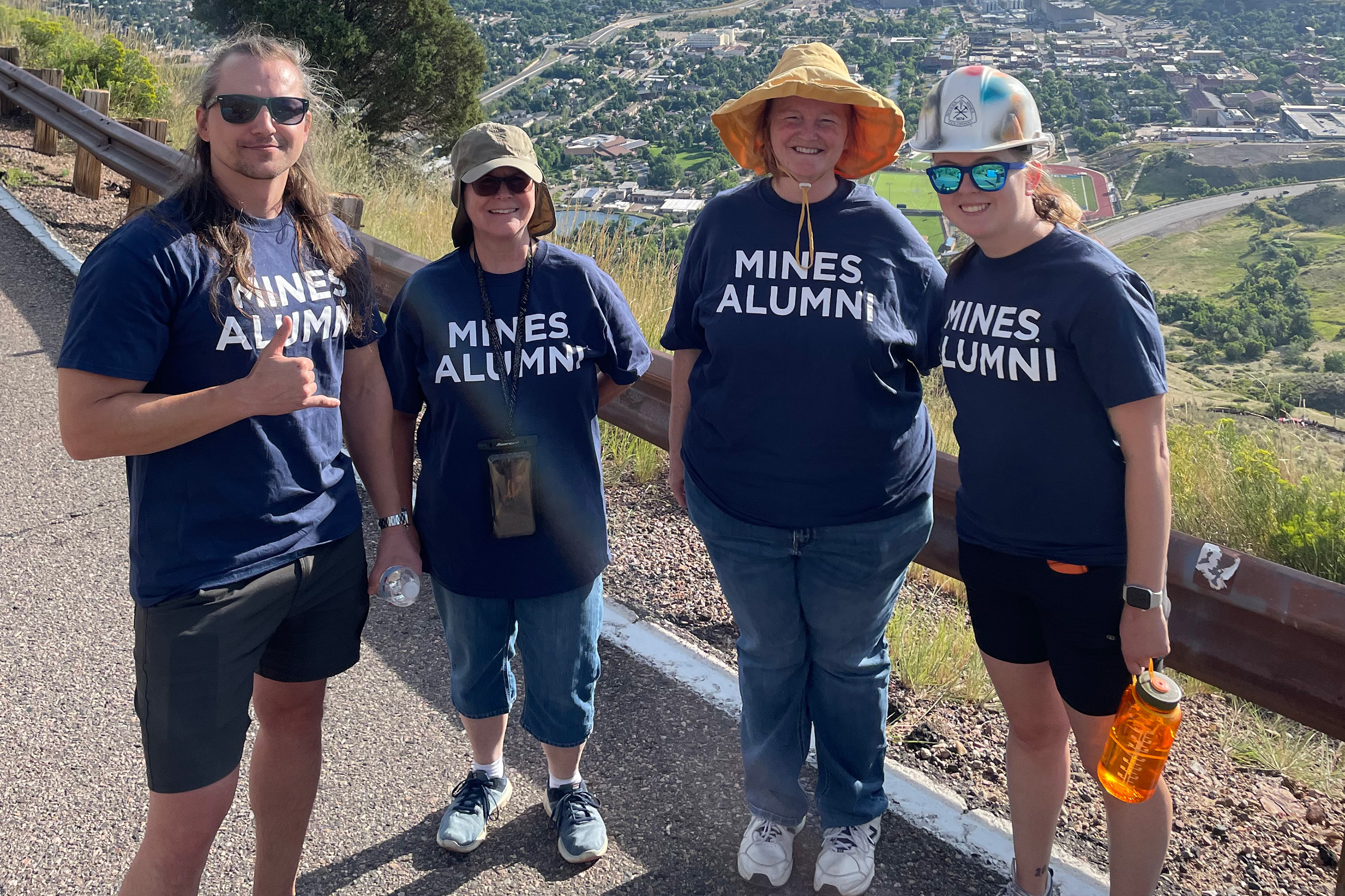 Four Mines alumni wearing Mines Alumni shirts on the M Climb