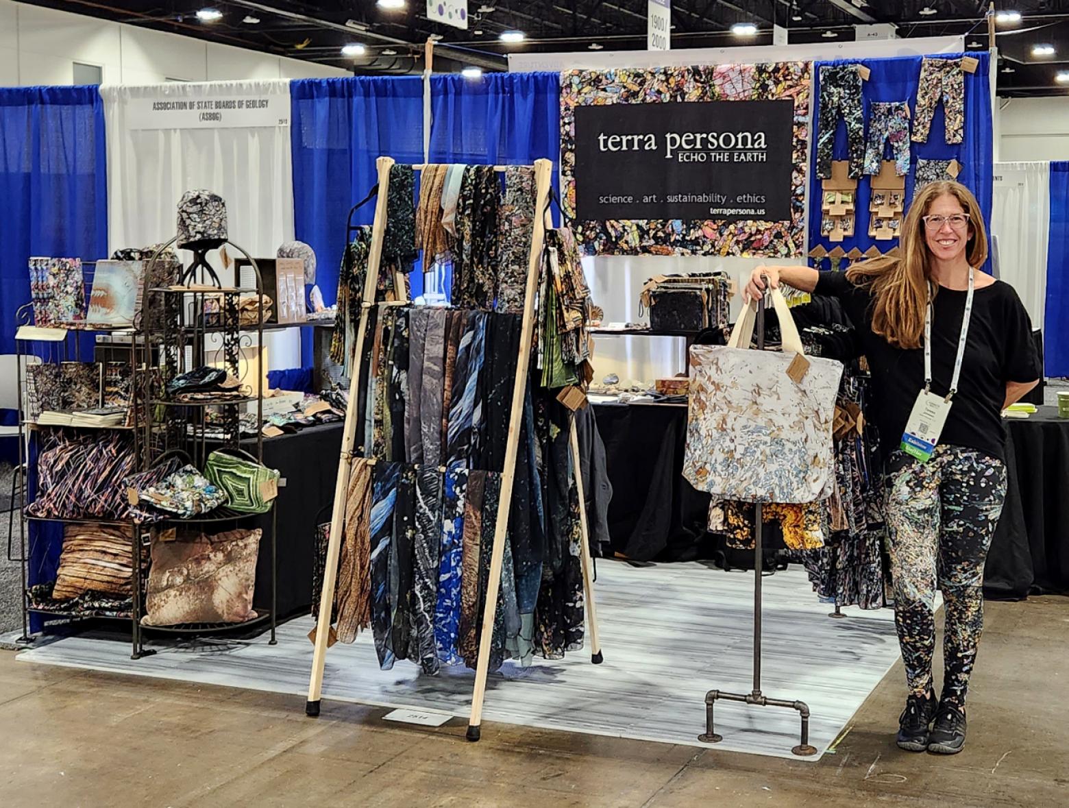 Mines Alum Teresa Johnson stands next to her apparel designs inspired by microscopic views of rocks and minerals.