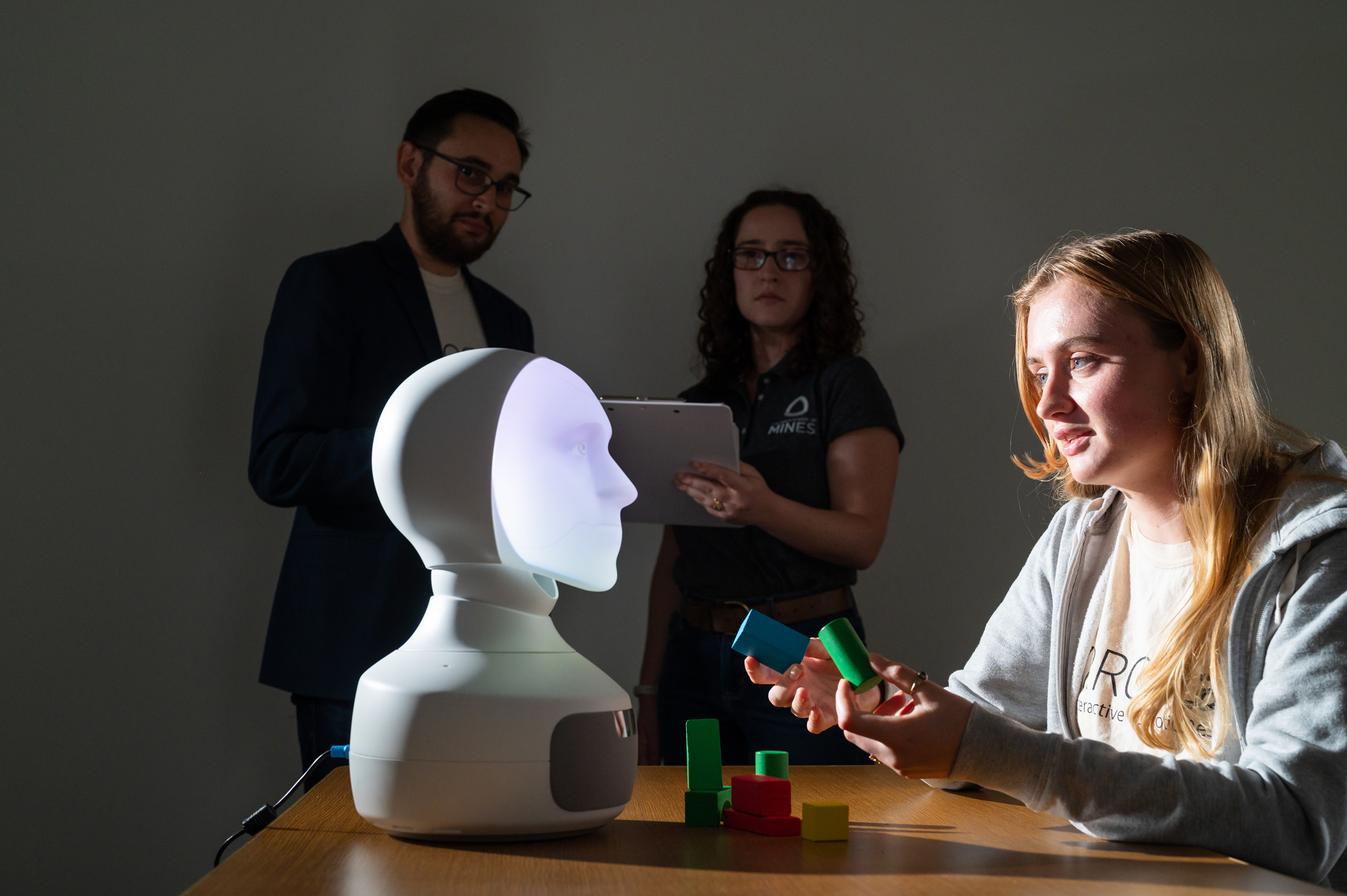 A student participates in a robotics experiment with a device designed like a human bust