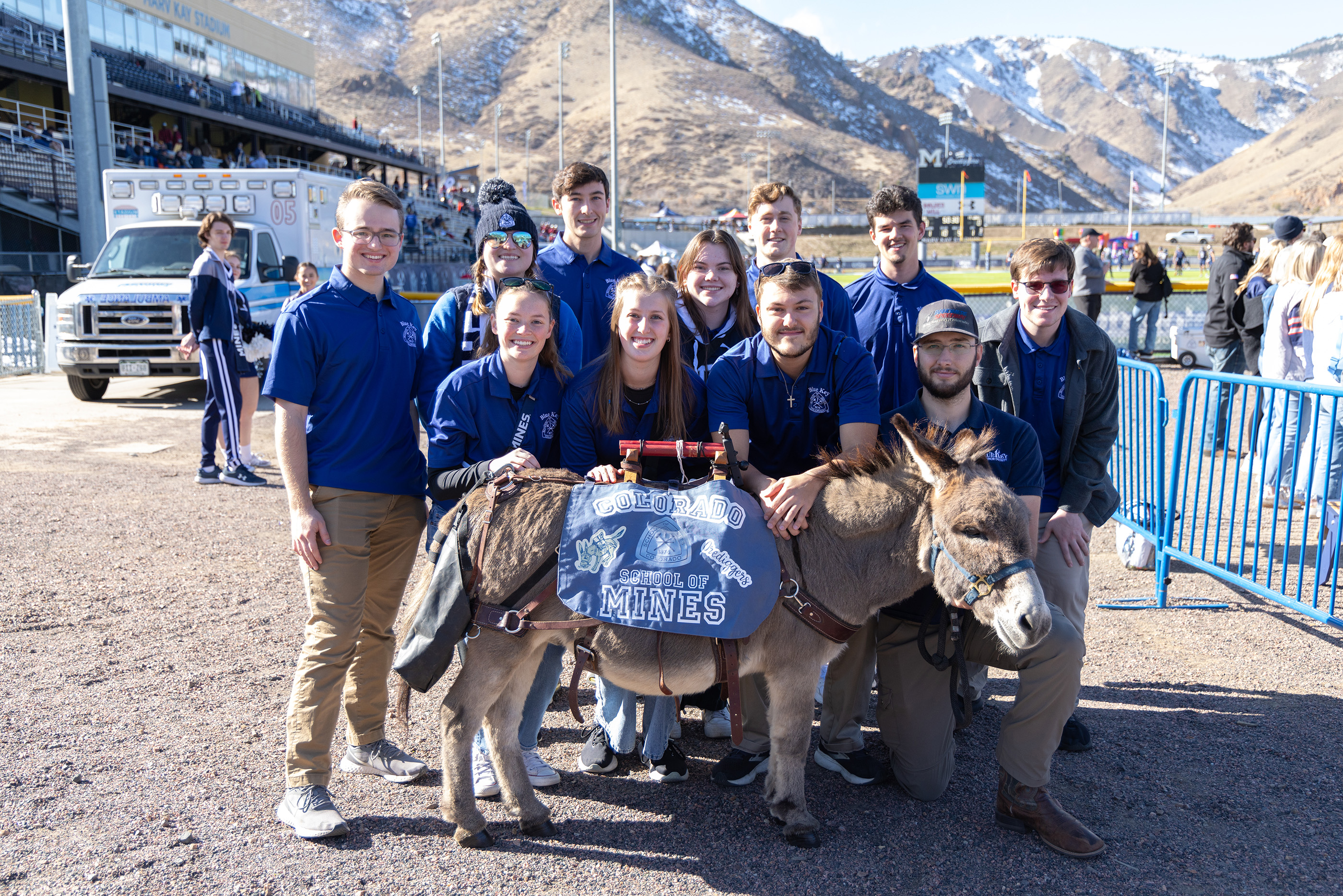 Mines students standing behind Blaster the Burro