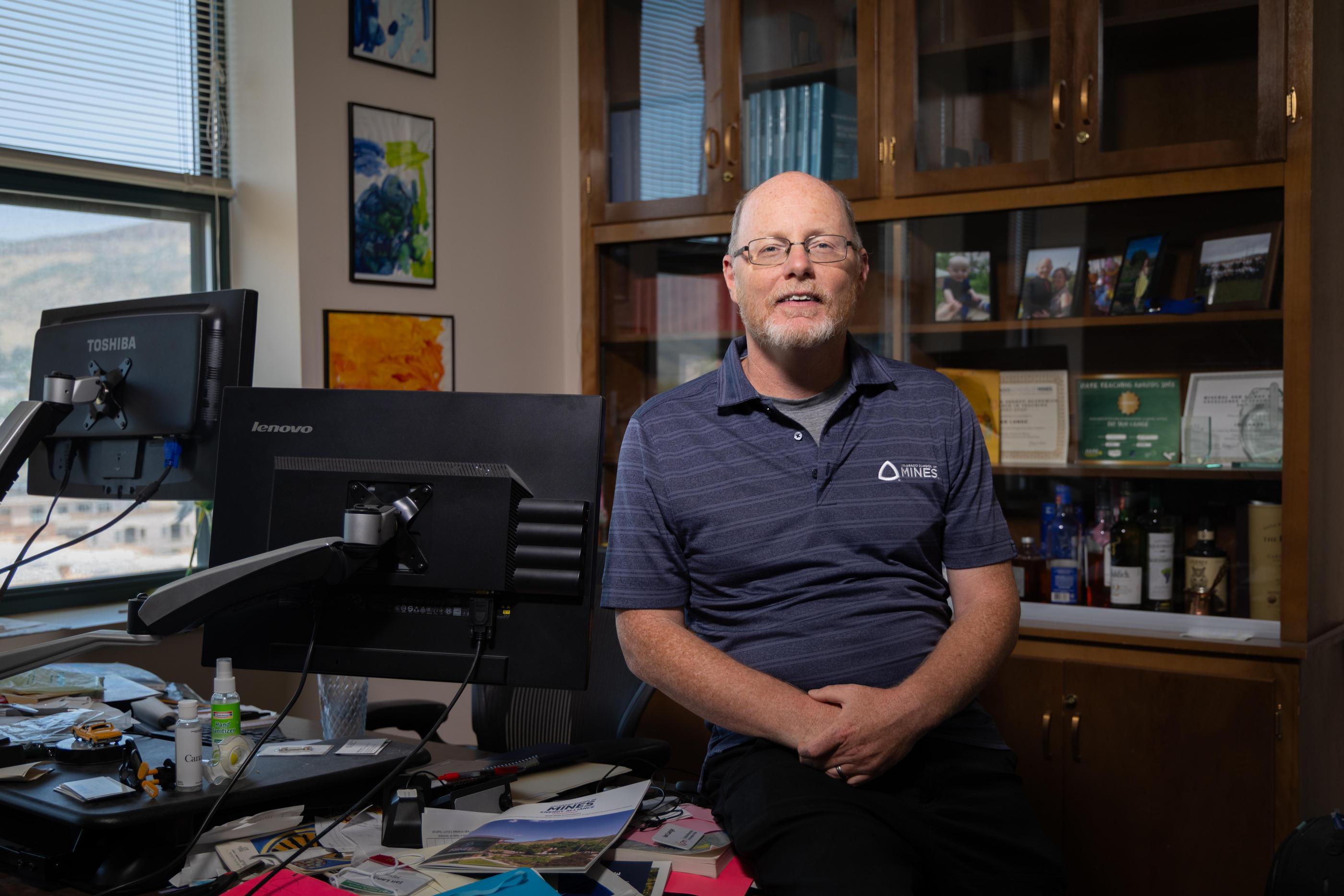 Ian Lange sits on his desk