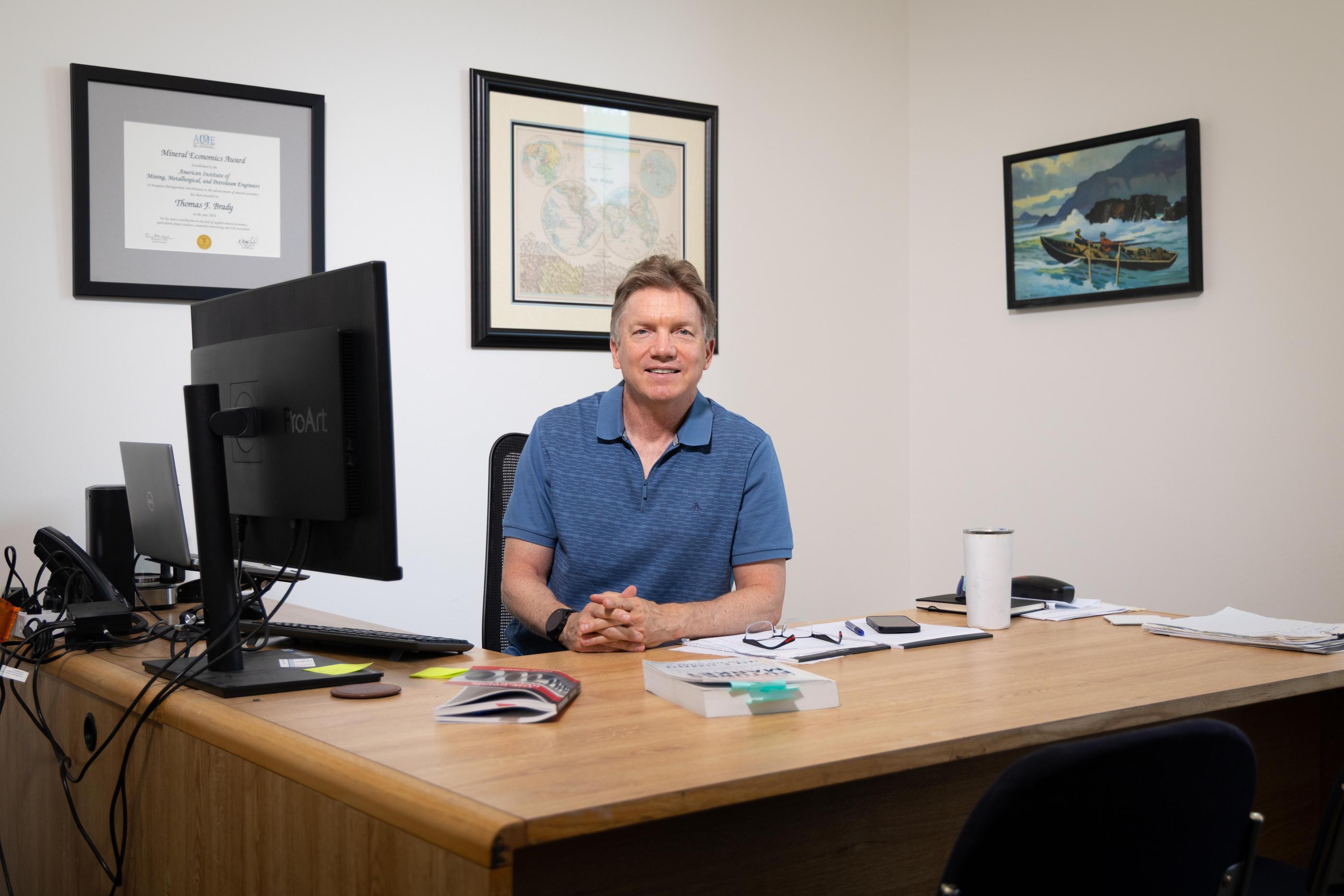 Tom Brady sits behind his desk