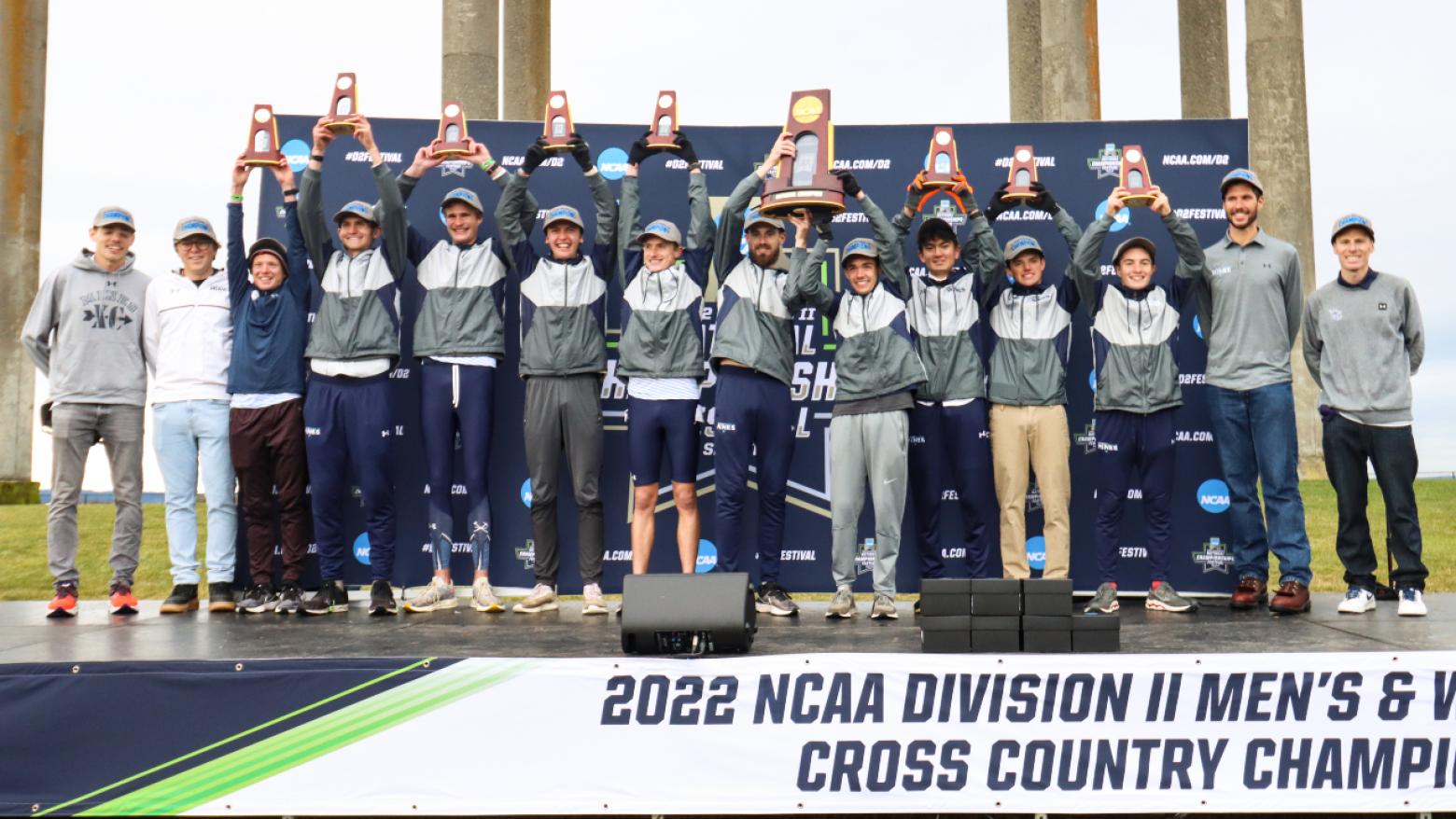 The Mines men's cross country team on the podium holding trophies